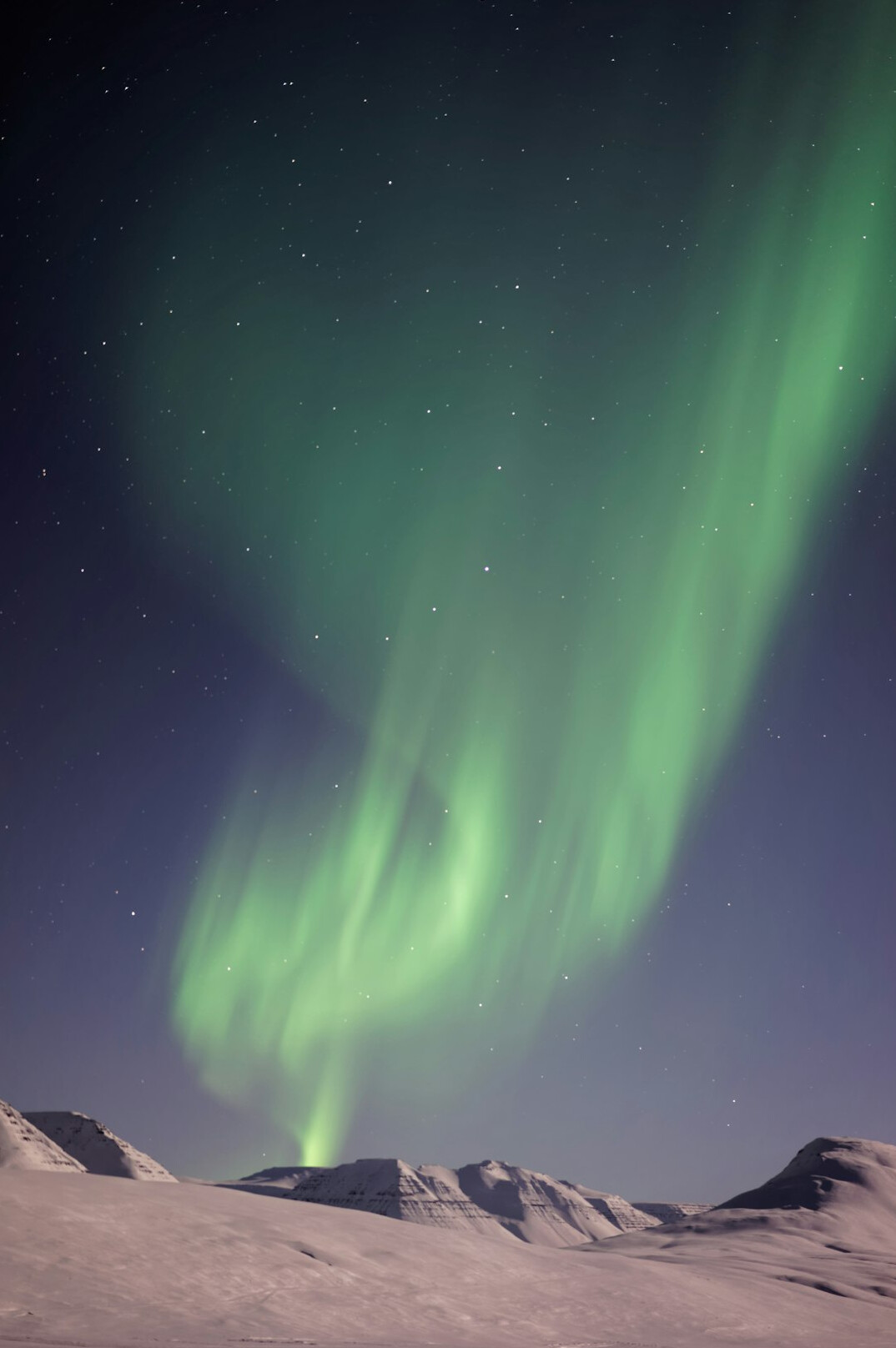 Northern lights over a snowy landscape in Iceland