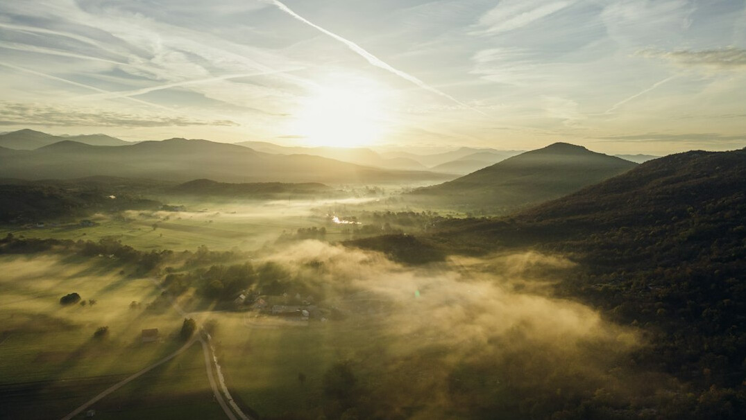 Sunrise over green hills and a quiet valley
